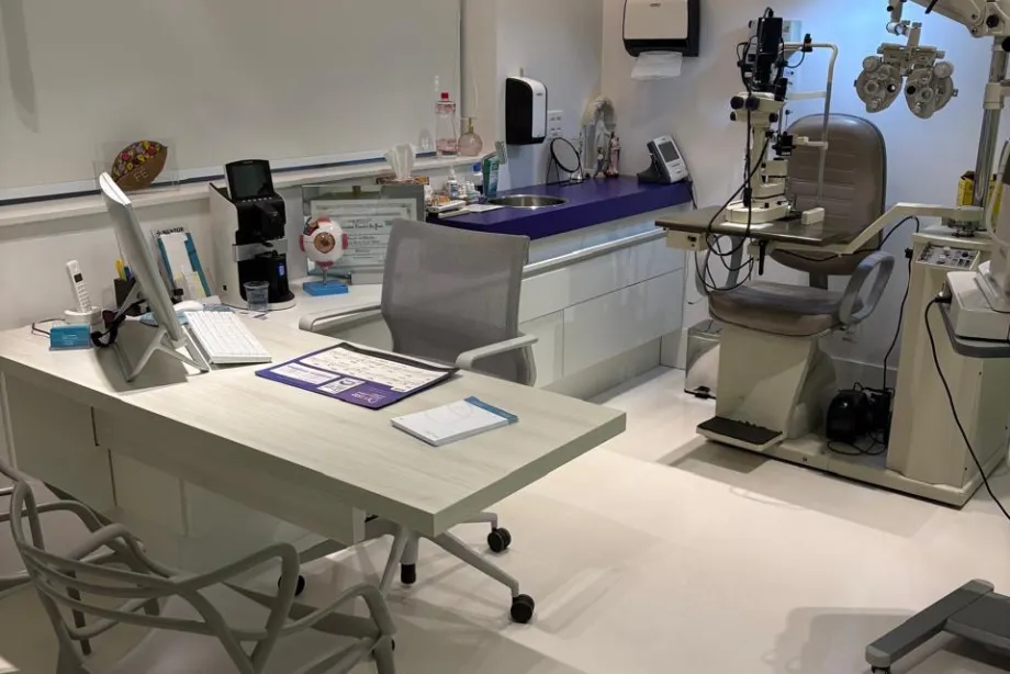 Sala de exames da clínica com lâmpada de fenda e refrator